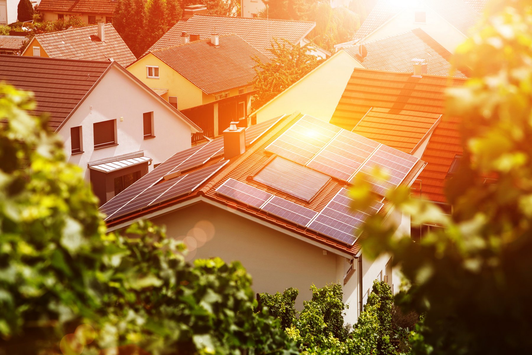 Sonnenkollektoren auf dem Ziegeldach eines Gebäudes in der Sonne. Bild zur Veranschaulichung von Energie, Eigenständigkeit, Autonomie und Sicherheit. 